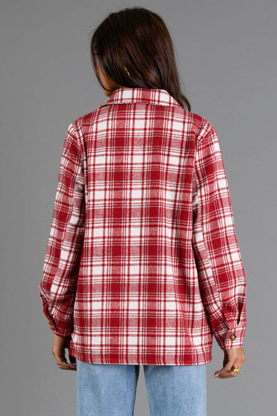 A person with long brown hair, seen from behind, models the Panache Apparel Collection Red & White Plaid Jacket with light blue jeans against a plain gray background.