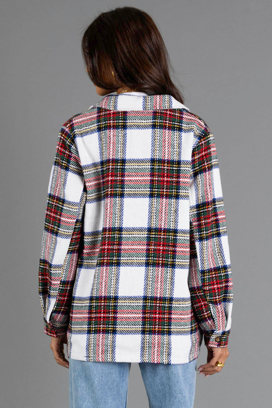 A person with long dark hair is shown from behind, wearing the Ivory & Multicolored Plaid Jacket from Panache Apparel Collection and light blue jeans against a plain gray background.