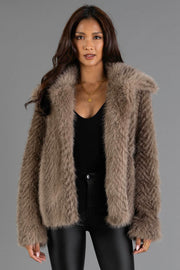 Model is wearing the Two Tone Faux Fur Jacket from Panache Apparel Collection over a black top and black pants, standing against a gray background.