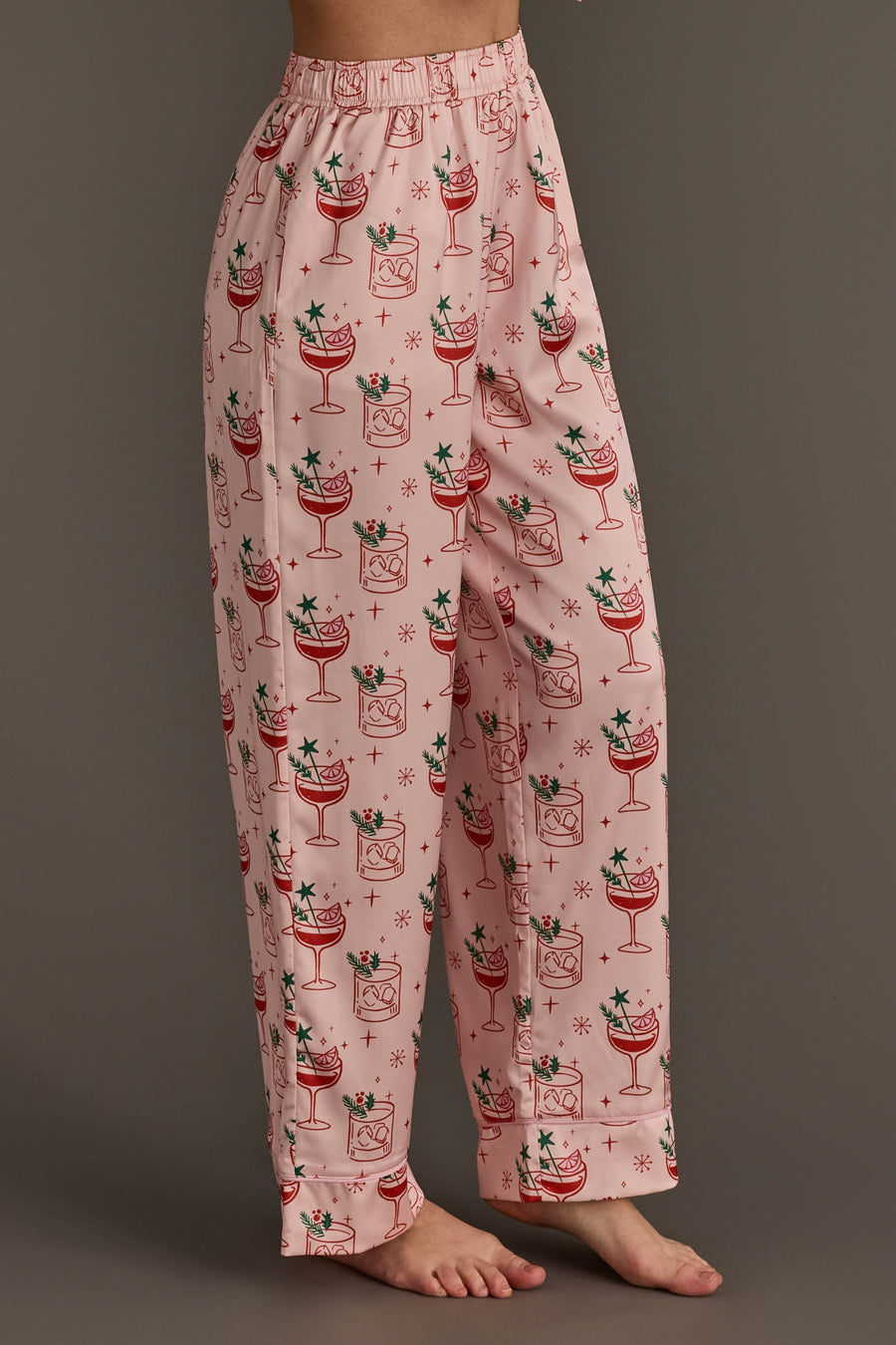 Light Pink Christmas Cocktails Satin Pajama set pants in light pink with a repeating pattern of holiday cocktails, lime slices, and small stars.