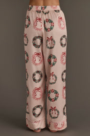 Light pink satin pajama pants from the Christmas Wreaths Satin Pajama Set featuring an all-over print of Christmas wreaths with red bows.