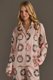 Light pink, long-sleeved button-down pajama top from the Christmas Wreaths Satin Pajama Set, featuring a Christmas wreath pattern and light pink piping.