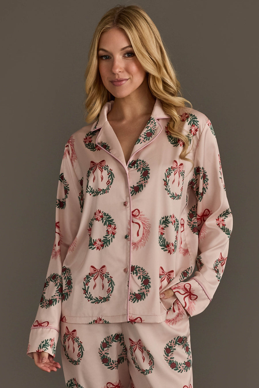 Light pink, long-sleeved button-down pajama top from the Christmas Wreaths Satin Pajama Set, featuring a Christmas wreath pattern and light pink piping.