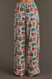Wide-leg festive holiday pajama pants from the Christmas Presents Satin Pajama Set featuring a repeating pattern of colorful Christmas gift boxes with bows.