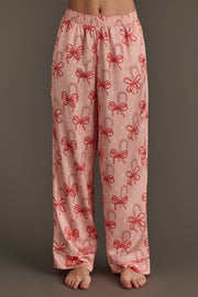 Light pink Candy Canes & Bows Satin Pajama Set pants featuring a repeating holiday loungewear pattern of red candy canes and bows.
