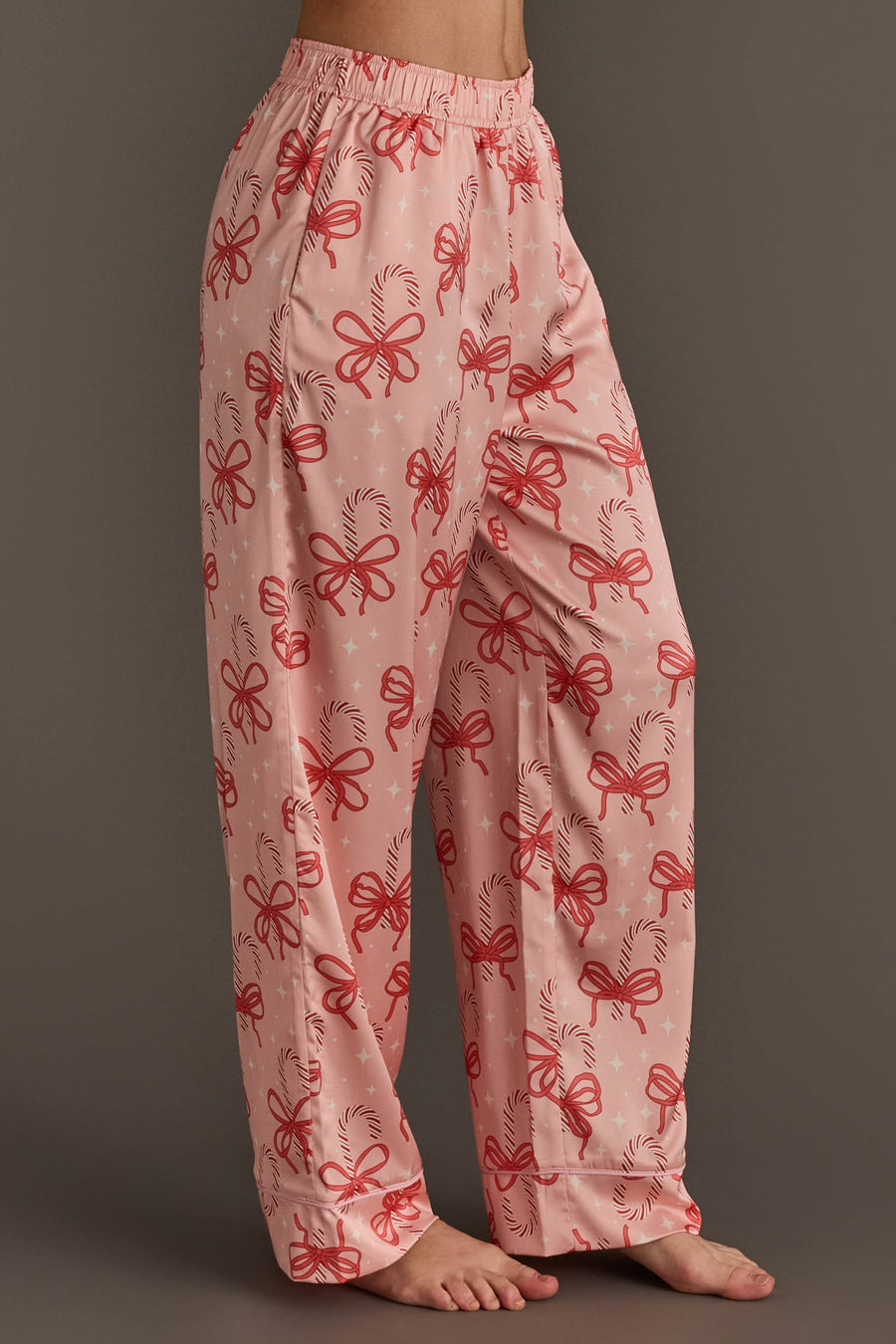 Light pink Candy Canes & Bows Satin Pajama Set pants featuring a red candy cane print and bows, perfect for holiday loungewear.