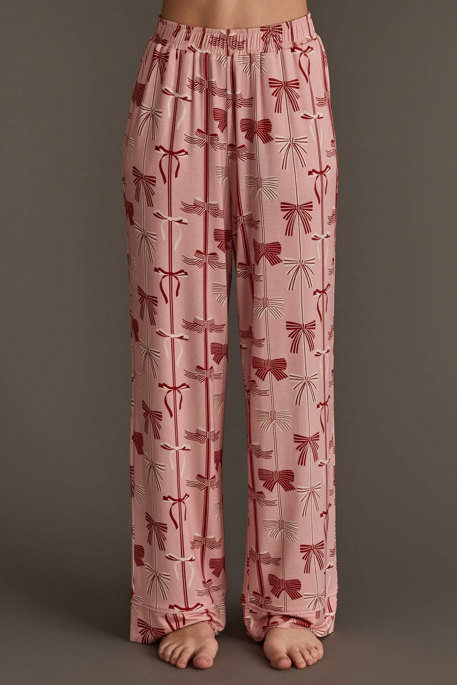 Pale pink Bows Jersey Pajama Set pants featuring a festive repeating pattern of red bows.