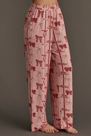 Light pink Bows Jersey Pajama Set pants in a jersey fabric featuring an all-over festive bow print with red and white bows and vertical lines.