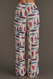 Champagne Bottles Jersey Pajama Set featuring festive loungewear pants with a white background and a pattern of colorful champagne bottles and gold stars.