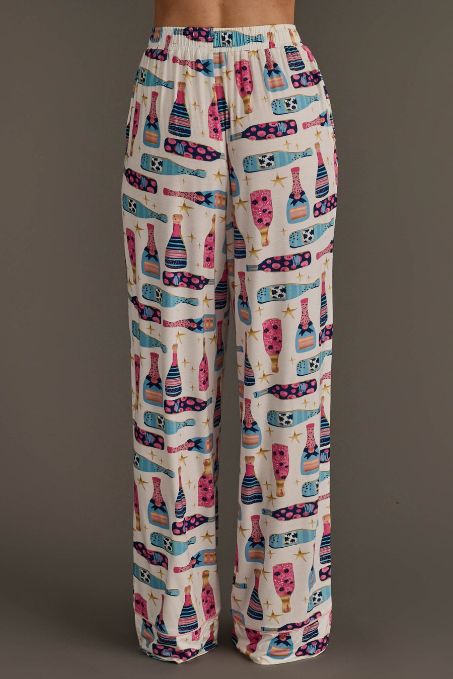 Champagne Bottles Jersey Pajama Set featuring festive loungewear pants with a white background and a pattern of colorful champagne bottles and gold stars.