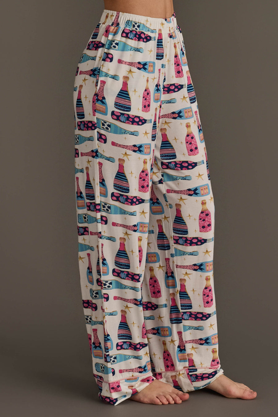 Champagne Bottles Jersey Pajama Set featuring light-colored lounge pants with a repeating pattern of champagne bottles and gold stars.