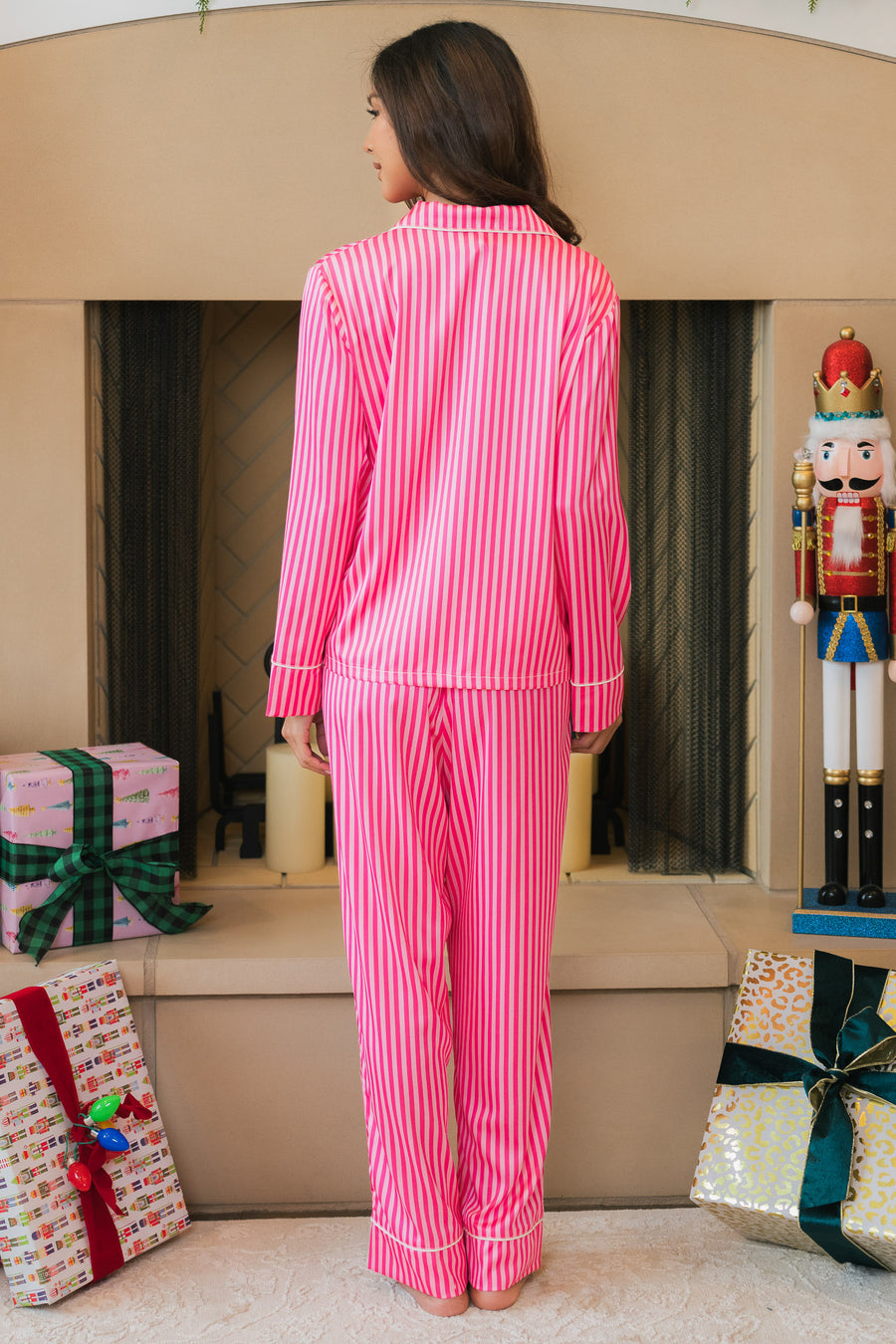 A person seen from behind wearing a Bright Pink & Light Pink Striped Satin Pajama Set, featuring long sleeves and vertical stripes.