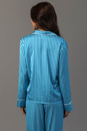 Back view of a person wearing a Blue & Light Blue Striped Satin Pajama Set, featuring a long-sleeved top and matching pants with white piping trim.