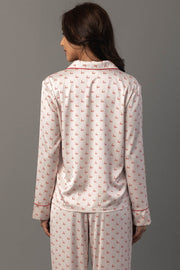 Back view of a person wearing an Ivory & Red Ho Ho Ho Satin Pajama Set featuring ivory sleepwear with a red ho ho ho print and red piping.