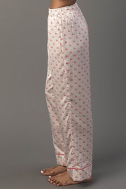 Ivory & Red Ho Ho Ho Satin Pajama Set pants in light-colored satin, patterned with small red ho text and finished with a red hem.