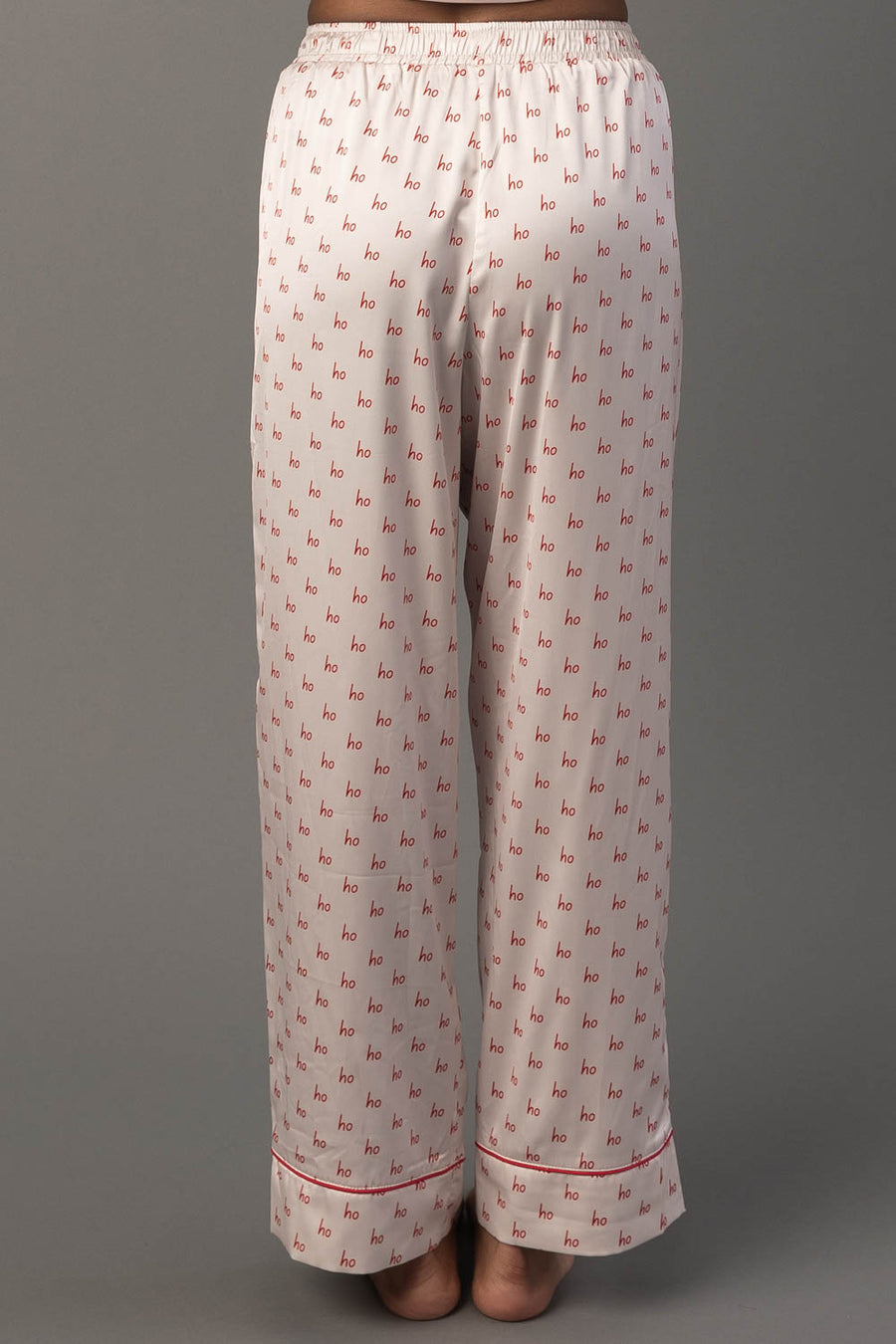 Ivory & Red Ho Ho Ho Satin Pajama Set pants in white satin with a repeating red Ho Ho Ho print and red piping at the cuffs.