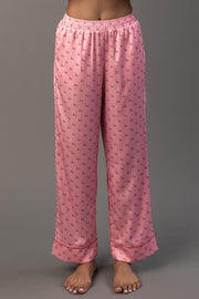 Light Pink & Red Ho Ho Ho Satin Pajama Set pants in light pink featuring a repeating red Ho Ho Ho print and red piping along the hems.