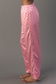 Side view of Light Pink & Red Ho Ho Ho Satin Pajama Set pants in light pink with a repeating red Ho Ho Ho print.