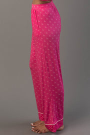 Side profile of Pink & Light Pink Ho Ho Ho Jersey Pajama Set pants in bright pink with an all-over repeating ho ho ho print and thin white trim at the ankles.