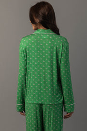 A person wears a Green & Light Pink Ho Ho Ho Jersey Pajama Set, featuring a long-sleeved top and matching pants covered in a repeating light pink ho ho ho pattern.