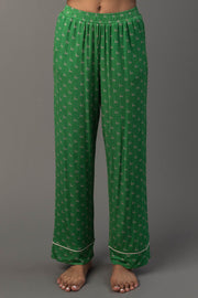 Green & Light Pink Ho Ho Ho Jersey Pajama Set featuring green pajama pants with a repeating light pink ho pattern and white trim at the ankles.