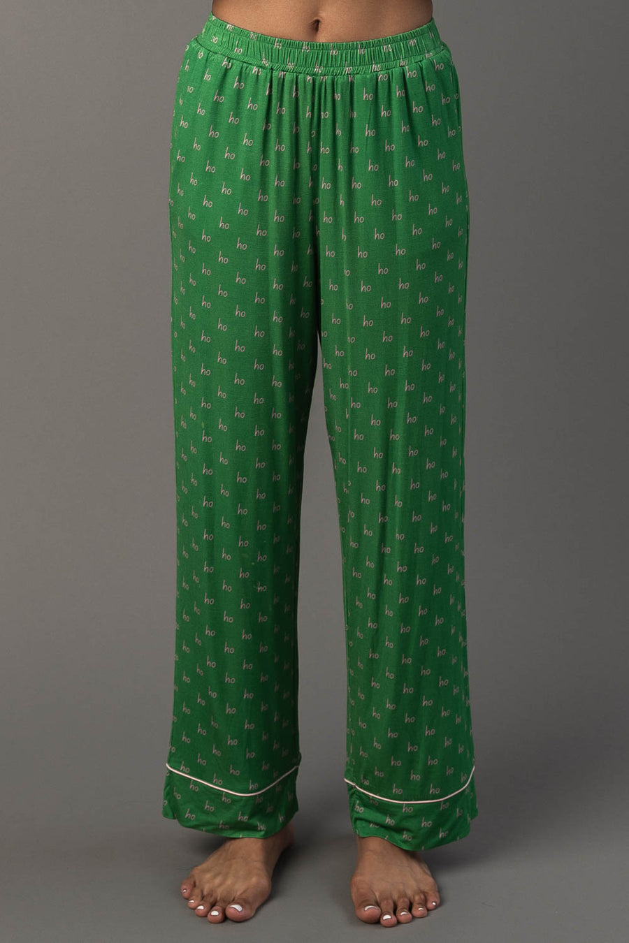 Green & Light Pink Ho Ho Ho Jersey Pajama Set featuring green pajama pants with a repeating light pink ho pattern and white trim at the ankles.