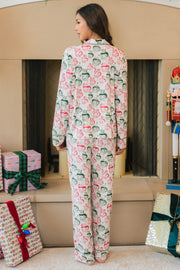 A woman stands with her back to the camera, wearing an Ivory Santa Mugs Jersey Pajama Set featuring an all-over print of festive mugs.
