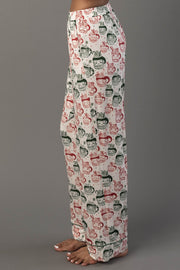 Side view of Ivory Santa Mugs Jersey Pajama Set pants featuring an all-over Santa mugs print in red and green.