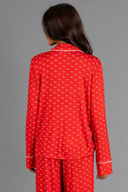 A person wearing a Red & White Ho Ho Ho Jersey Pajama Set featuring a repeating white print and white piping.