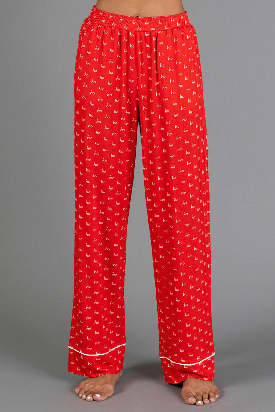 Red & White Ho Ho Ho Jersey Pajama Set featuring red holiday pajama pants with an all-over white ho ho ho print and white hem trim.