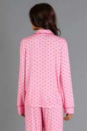 Back view of a person wearing a Light Pink & Red Ho Ho Ho Jersey Pajama Set with a repeating red ho ho ho print and red piping.