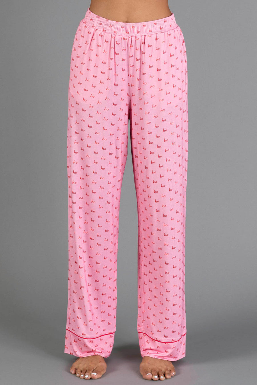 Light Pink & Red Ho Ho Ho Jersey Pajama Set pants in light pink jersey featuring a repeating red ho ho ho print and red piping at the cuffs.