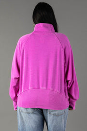 A person with long dark hair is shown from the back, wearing the Panache Apparel Collection’s Purple Quarter Zip Sweatshirt and light blue jeans, standing against a plain gray background.