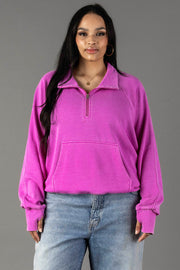 A woman with long dark hair wears the Panache Apparel Collection Purple Quarter Zip Sweatshirt and light blue jeans, standing against a plain gray background.