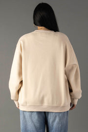 A person with long dark hair, shown from the back, wears a Tan Coffee Weather Sweatshirt by Panache Apparel Collection and light blue jeans against a plain gray background.