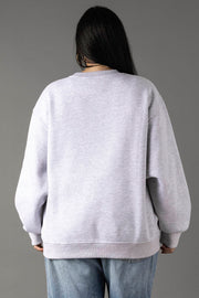 A person with long dark hair stands with their back to the camera, wearing Panache Apparel Collection's Gray Margarita Weather Sweatshirt and blue jeans against a plain gray background.