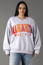 A woman with long dark hair wears the Panache Apparel Collection Gray Margarita Weather Sweatshirt, featuring a soft fleece interior, paired with light blue jeans against a plain gray background.