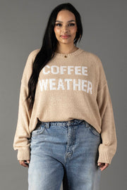 A woman models the Panache Apparel Collection’s Tan & Ivory Coffee Weather Lightweight Sweater against a plain gray background, standing with relaxed hands and a slight smile.