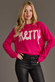 A woman wears a Pink & Light Pink Merry Sweater, a bright pink knit sweater with the word merry written in light pink letters across the front.