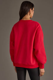 A person with long dark hair, dressed in the Panache Apparel Collection’s Red & Black Game Day Sweatshirt and black pants, stands facing away from the camera against a plain background.