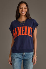 A woman wearing the Panache Apparel Collection's Navy & Orange Game Day Short Sleeve Sweatshirt and light blue jeans, smiling against a plain gray background.