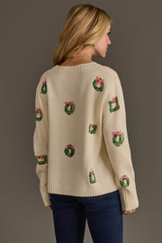 Ivory Wreath Sweater with Pink Bows in cream, featuring a pattern of small green wreaths tied with pink bows on a long-sleeve silhouette.
