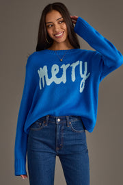A person wears a Royal Blue & Light Blue Merry Sweater, a royal blue long-sleeved sweater with the word merry knit in light blue across the chest.