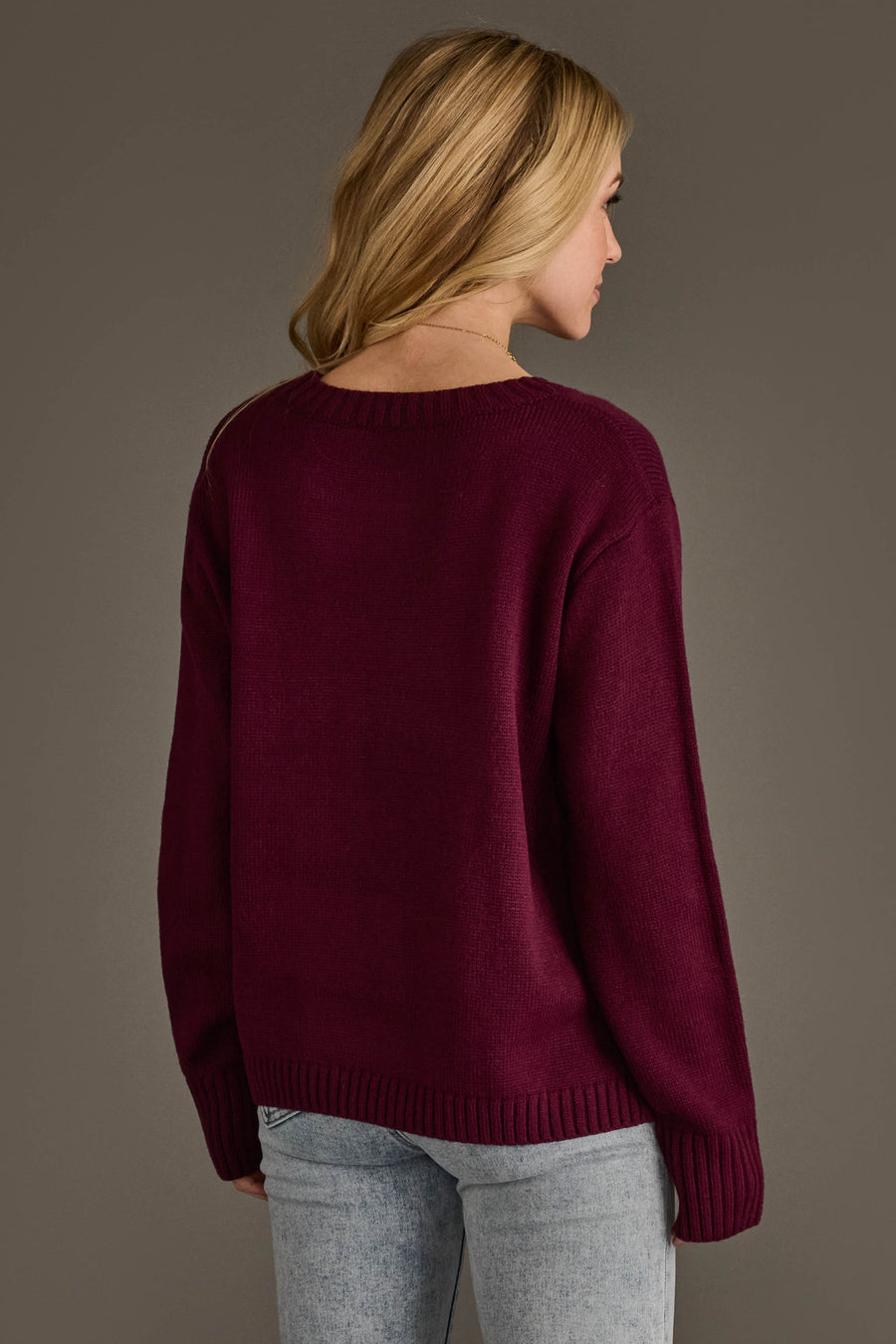 A person seen from behind wearing a Wine Merry Sweater by Panache Apparel Collection, a deep red long-sleeved crewneck with ribbed cuffs and hem.