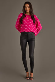 A person wearing a Bright Pink & Light Pink Ho Ho Ho Sweater, black skinny pants, and black heeled sandals.