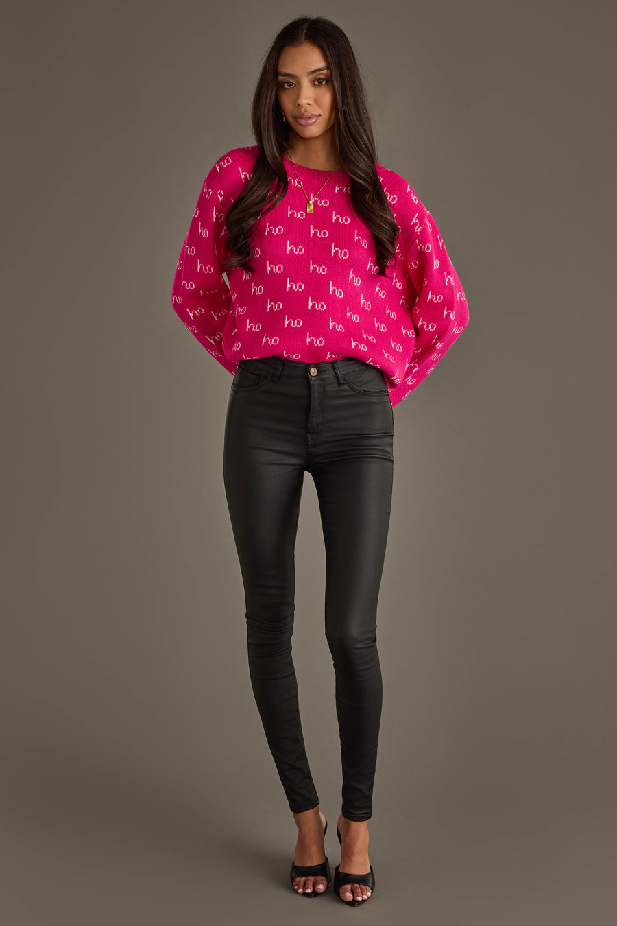 A person wearing a Bright Pink & Light Pink Ho Ho Ho Sweater, black skinny pants, and black heeled sandals.
