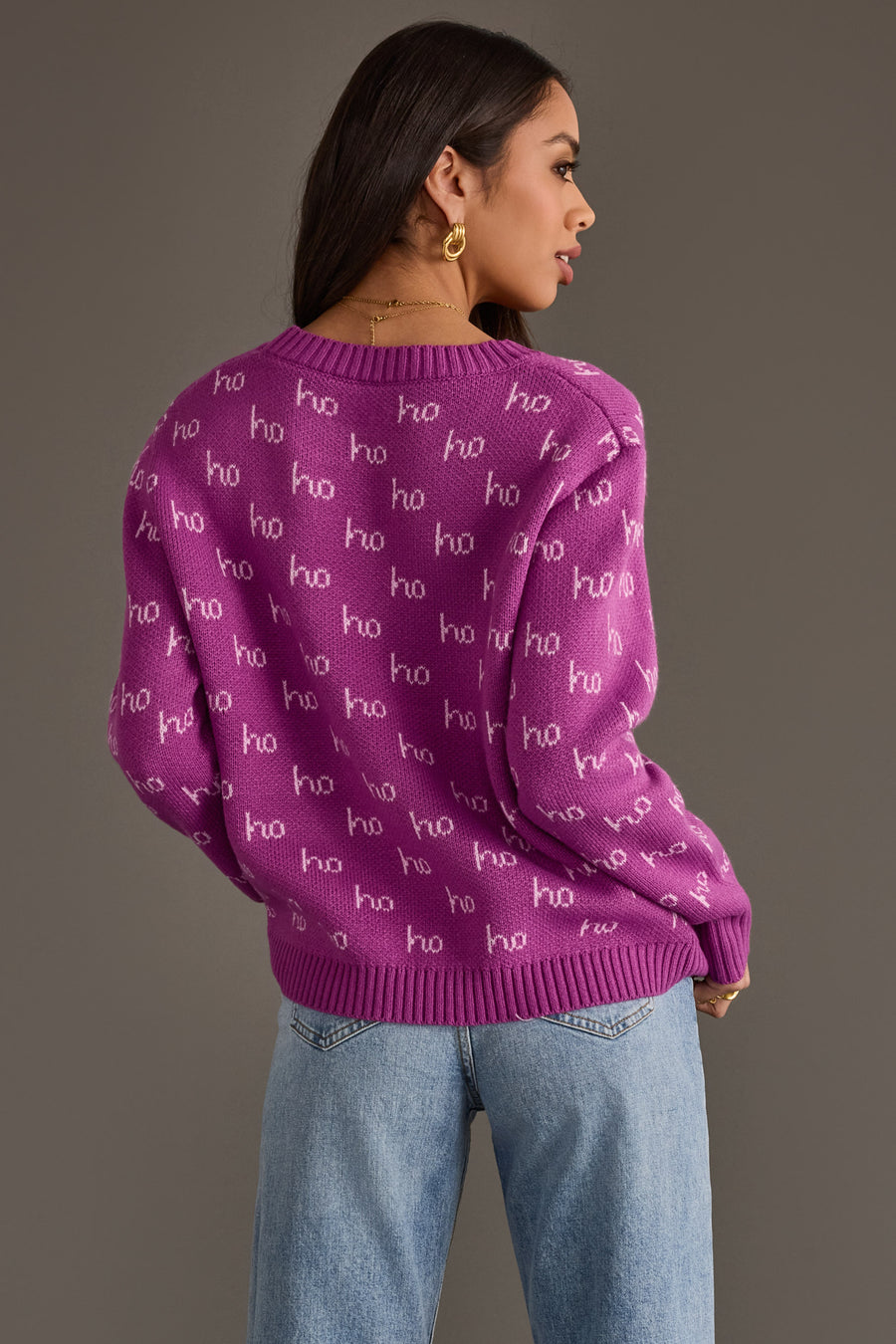 Purple Ho Ho Ho Sweater with a white ho pattern, worn with light blue jeans.