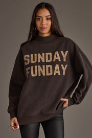 A woman with long, dark hair stands against a gray background, wearing the Panache Apparel Collection’s Dark Gray Game Day & Sunday Funday Reversible Sweatshirt. She looks at the camera with a relaxed expression, showcasing the bold "SUNDAY FUNDAY" lettering on the front.