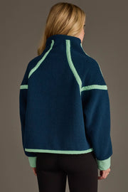 A woman with long blonde hair, shown from behind against a plain background, wears the Panache Apparel Collection Navy & Mint Half Zip Sherpa Fleece Sweatshirt paired with black pants.
