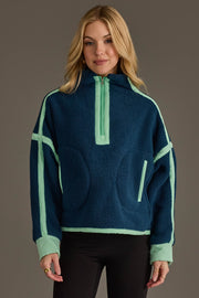 A woman with long blonde hair is wearing the Panache Apparel Collection Navy & Mint Half Zip Sherpa Fleece Sweatshirt, standing against a plain background and smiling softly at the camera.